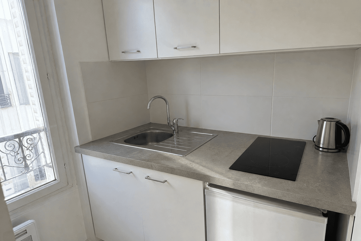 Plan de travail essuyé et évier vide dans une kitchenette